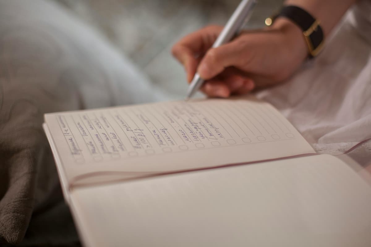 Person writing in a journal while reflecting on daily habits, personal growth, and healthy lifestyle routines.