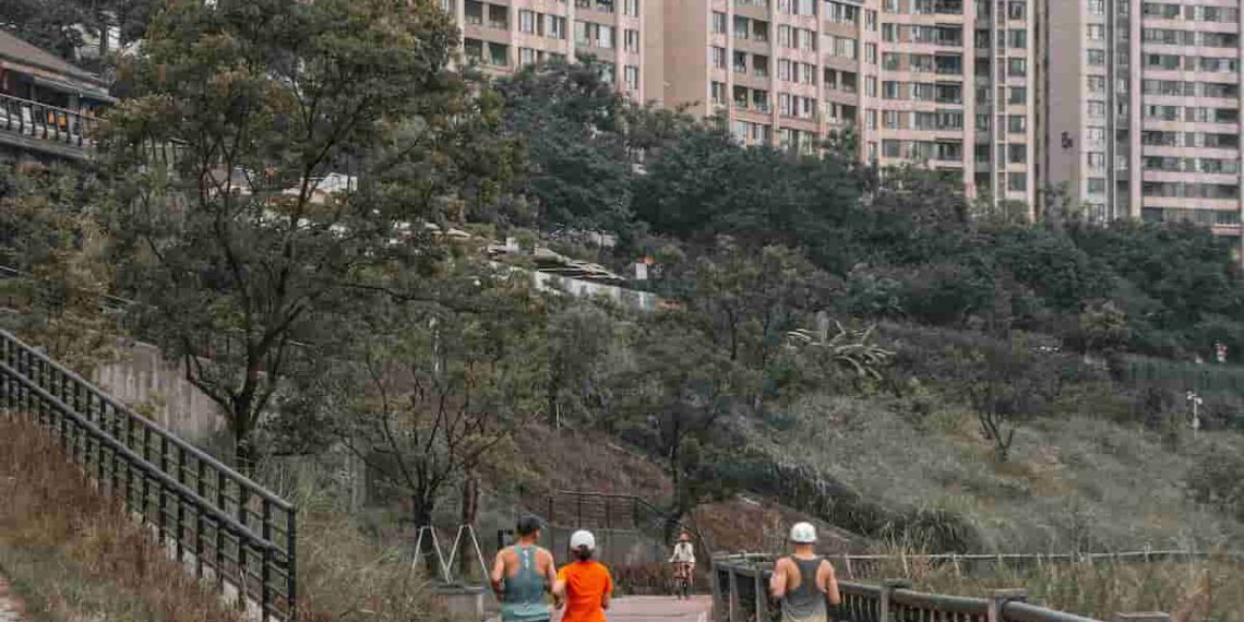 A group of people running through a city pathway, showing running can be a simple and accessible way for anyone to build a healthier and more sustainable weight loss journey.