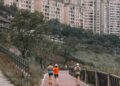 A group of people running through a city pathway, showing running can be a simple and accessible way for anyone to build a healthier and more sustainable weight loss journey.