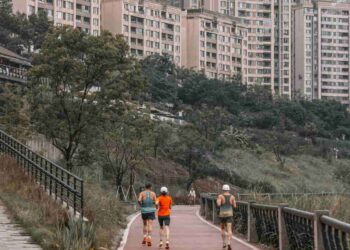A group of people running through a city pathway, showing running can be a simple and accessible way for anyone to build a healthier and more sustainable weight loss journey.