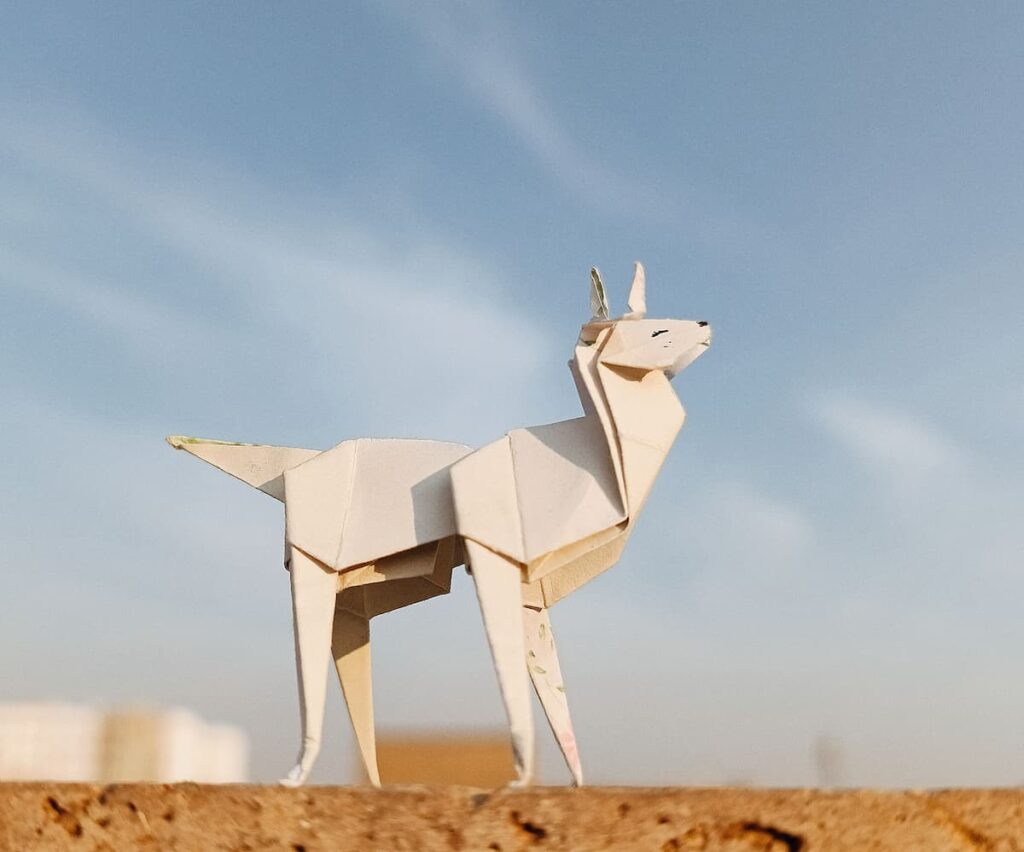 A handmade origami displayed outdoors against a blue sky.