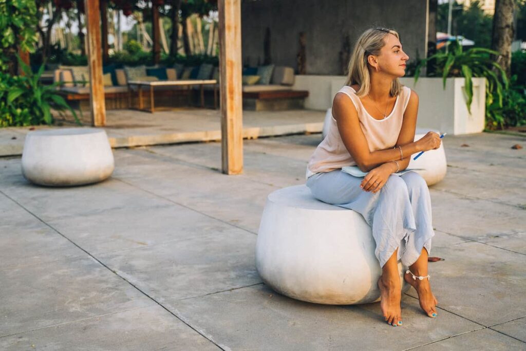 A woman sitting outdoors and enjoying a peaceful moment in nature.