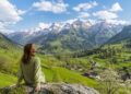 Woman enjoying a peaceful spring view of the Swiss mountains and green valley