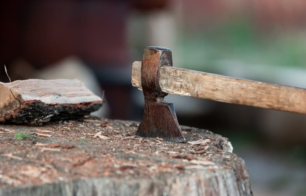 An axe stuck in a tree stump, showing the effort to break through struggles that can lower self-worth