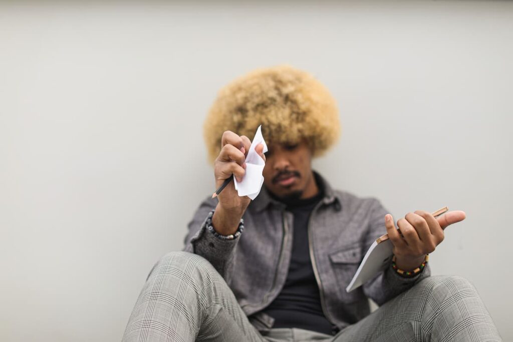 A man holding a crumple paper while looking discouraged, struggling to get go of a past mistake