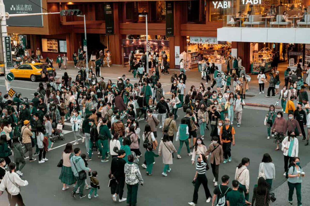 A busy city street filled with people walking in different directions.